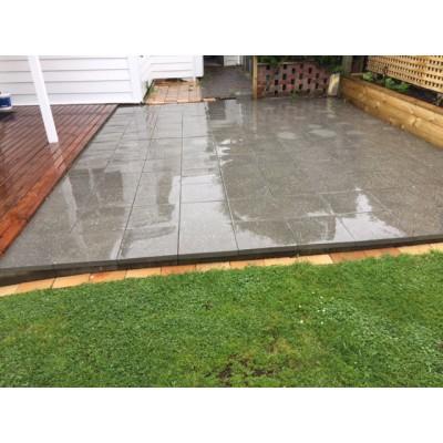 Exposed aggregate concrete paving slabs laid in a residential backyard